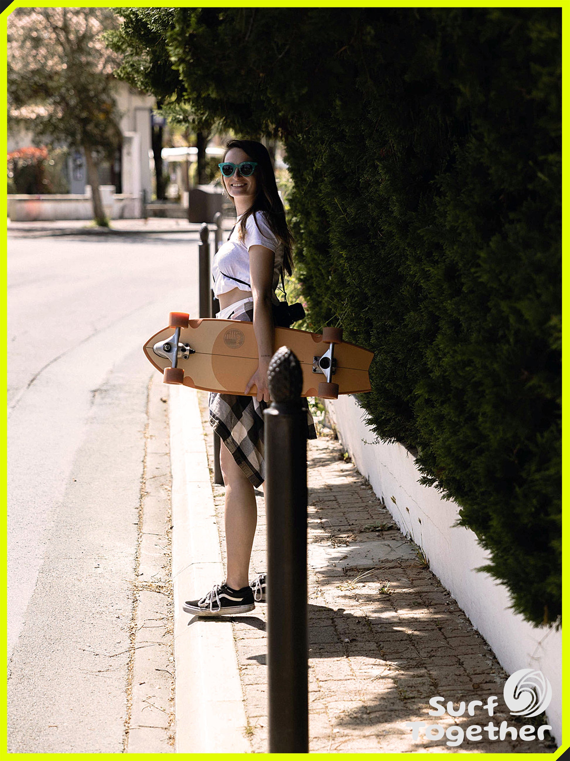 Estilo de Vida | Slide | Fish 3/4 Patch 32” SurfSkate | Chica en la calle sosteniendo el SurfSkate