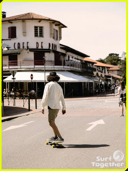 Estilo de Vida | Slide Gussie Spoon 31" SurfSkate | Chico sobre SurSkate frente a Cafe de Paris 